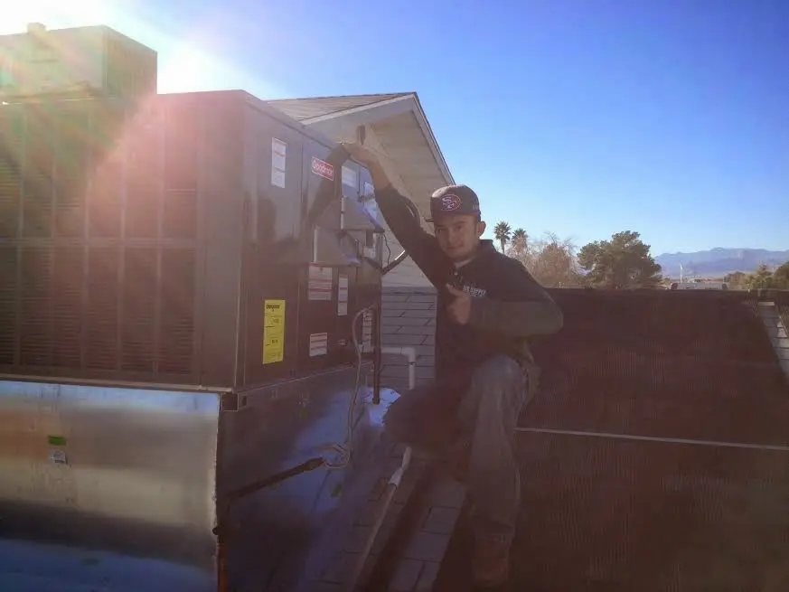 HVAC technician performing HVAC Inspection on a rooftop unit in Lexington